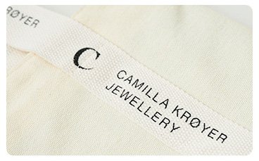 Screen printed logo on a natural canvas bag strap — Camilla Krøyer Jewellery